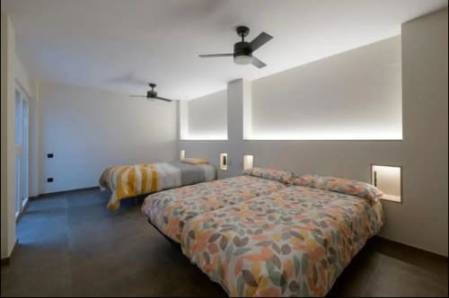 Dormitorio moderno en ML Apartments Valencia con dos camas, ventiladores de techo, espejos iluminados y diseño minimalista oscuro