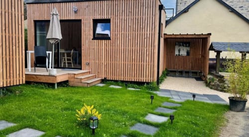 Élégant lodge en bois aux Logis du Canal à Betton avec terrasse, parasol et allée de jardin