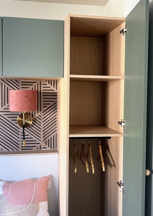 Armoire en bois ouverte du studio Haut Chalet aux Logis du canal, avec étagères et cintres pour le rangement