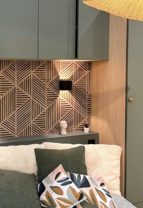 Chambre moderne aux Logis du canal avec tête de lit géométrique en bois, coussin d'accent vert et housse motifs