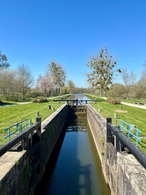Écluse du canal et voie navigable aux Logis du canal, Betton, avec berges ombragées et paysage verdoyant