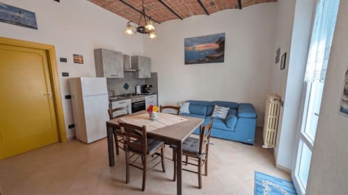 Appartamento Raggio di Luna a Villa Italia con cucina, tavolo da pranzo, divano blu e pavimento in cotto