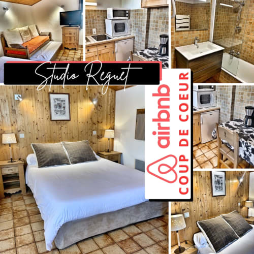 Studio Reguet at Chez Francine: Wood-paneled bedroom with white bed, kitchenette, bathroom, and tiled flooring in Notre Dame