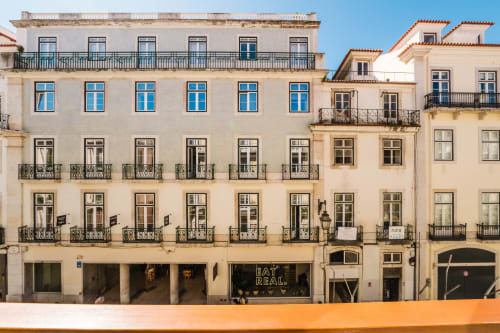 Historic Lisbon building facade with blue windows, wrought iron balconies, and ground-floor restaurant entrance, GS Chiado