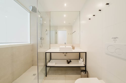 Modern bathroom in GS Chiado Boutique Studios, Lisbon with walk-in shower, vanity sink, and contemporary black frame fixtures