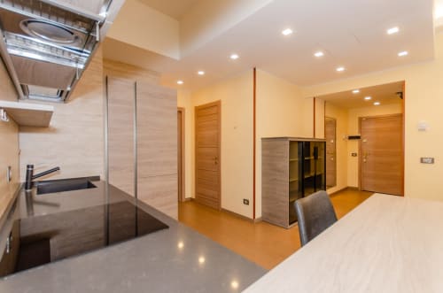 Cucina e zona living di moderno appartamento a Milano con finiture in legno, TV e WiFi a Porta Nuova Home