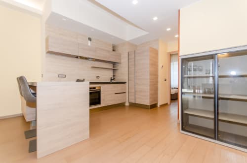 Cucina e zona pranzo moderna dell'appartamento Porta Nuova Home di Milano Hospitality con mobili in legno chiaro e layout aperto