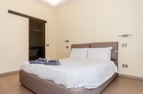 Camera moderna di Milano Hospitality Porta Nuova Home con letto matrimoniale, biancheria bianca e arredamento contemporaneo