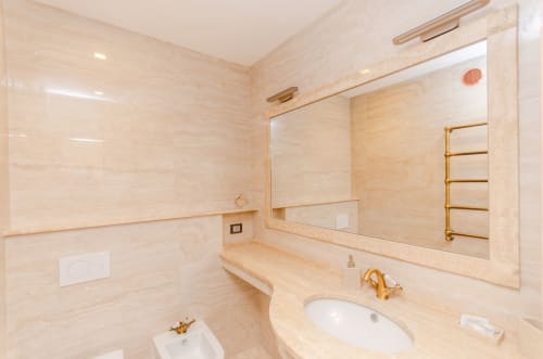Bagno lussuoso Porta Nuova a Milano Hospitality con marmi, finiture dorate e ampio specchio