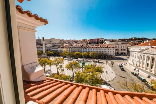 Vista do Rossio e paisagem histórica de Lisboa da varanda da Suíte Loft do Hotel Liberator Rossio, com telhado de barro