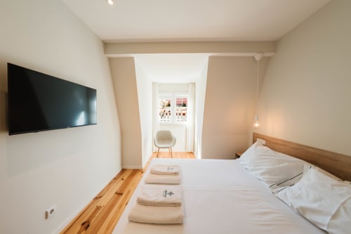 Quarto suite loft moderno do Liberator Rossio Hotel Lisboa com TV na parede, piso em madeira e espaço de trabalho