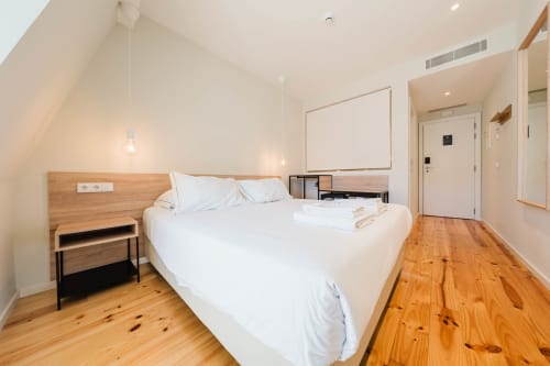 Suíte loft moderna no Hotel Liberator Rossio em Lisboa com cama queen, assoalho em madeira e decoração minimalista