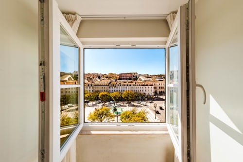 Janela aberta da suíte loft do Liberator Rossio Hotel com vista para a Praça do Rossio e edifícios históricos de Lisboa, Portugal