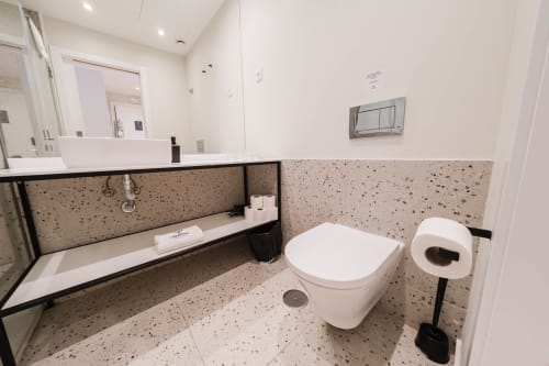 Banheiro moderno do Liberator Rossio Hotel Lisboa com ladrilhos de terrazzo, sanita suspensa e lavatório flutuante