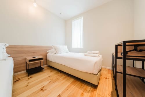 Quarto de família luminoso no Hotel Liberator Rossio Lisboa com cama de madeira, luz natural e comodidades modernas