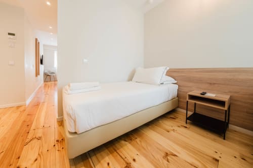 Quarto moderno com piso em madeira e cama no Hotel Liberator Rossio em Lisboa
