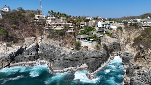 Cabaña Casa Baori sobre los acantilados de Puerto Ángel, con olas turquesas y formaciones rocosas costeras