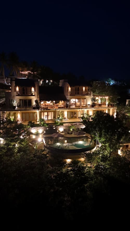Resort frente al mar Casa Baori de noche, iluminación ambiental, piscina infinita y terrazas con vistas a Puerto