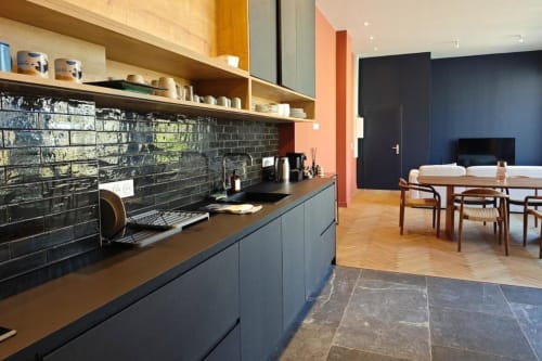 Cuisine ouverte et salle à manger modernes à l'hôtel O LIT avec dosseret en carrelage noir, étagères en bois et mobilier années 50