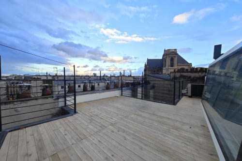 Terrasse sur le toit de l'appartement O LIT en France avec terrasse en bois, vue sur les toits de la ville et garde-corps de sécurité