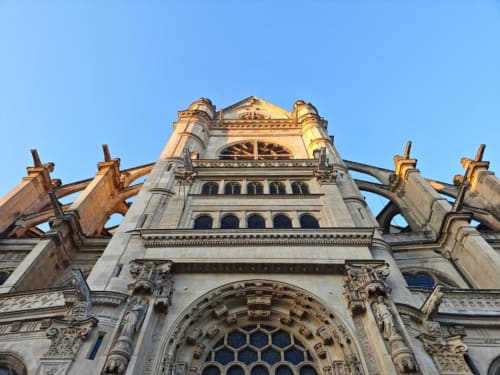 Flèche de cathédrale gothique avec ornements en pierre finement travaillés sous un ciel bleu dégagé à Paris, France