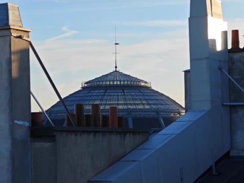 Vue de l'appartement O LIT en France montrant un bâtiment au dôme bleu distinctif avec architecture industrielle et panorama urbain