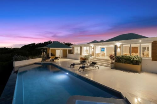Villa de luxe à O LIT avec piscine privée illuminée, transats et terrasse moderne au crépuscule avec vue sur l'océan
