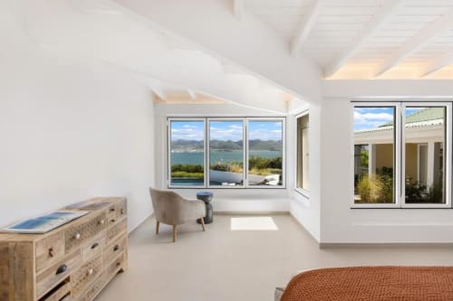 Chambre lumineuse avec vue mer, grande fenêtre, commode en bois, coin détente et équipements modernes à O LIT