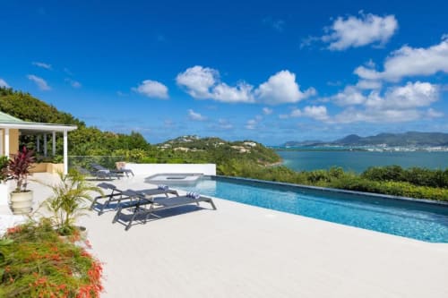 Villa de luxe avec piscine privée surplombant la baie turquoise, transats blancs et vue côtière près de Saint-Barthélemy