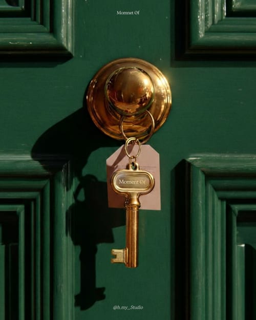 Clé en laiton avec étiquette « Moment Of » suspendue à la porte verte de l'hôtel ARLOÉ La Rochelle
