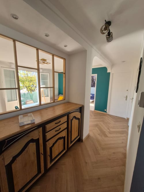 Couloir moderne de l'Accolade Châteaudun avec bureau en bois, paroi vitrée, parquet chevrons et mur d'accent bleu-vert