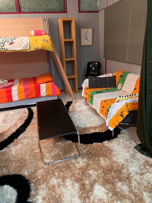 Dormitorio compartido en los apartamentos Tessa en Sabadell con literas, ropa de cama colorida, alfombras beige y diseño moderno