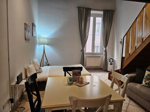 Camera da letto in appartamento vaticano con tavolo da pranzo, letto, finestra con vista sulla città e comfort moderni a Roma