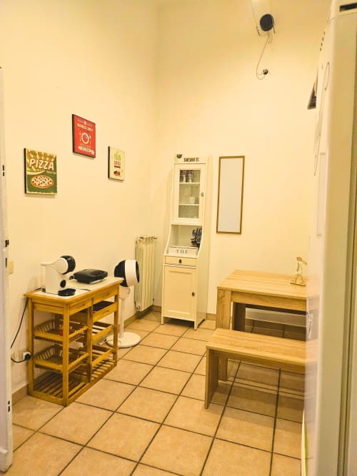Luminosa zona cucina-living nell'Appartamento Vaticano a Roma con mobili in legno, pavimenti in piastrelle e arredamento vintage su muri gialli