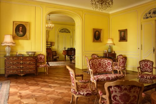 Élégant salon jaune du Château de Varambon avec mobilier damassé bourgogne et parquets en bois ouvragé
