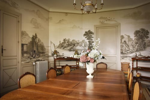 Élégante salle à manger du Château De Varambon avec table en bois, chaises cannées et fresques murales pittoresques