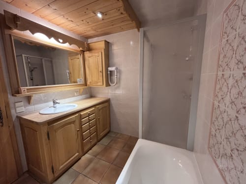 Modern bathroom in Chez Marion apartment at Chez Francine, Notre Dame de Bellecombe, with wooden vanity, shower, and stone
