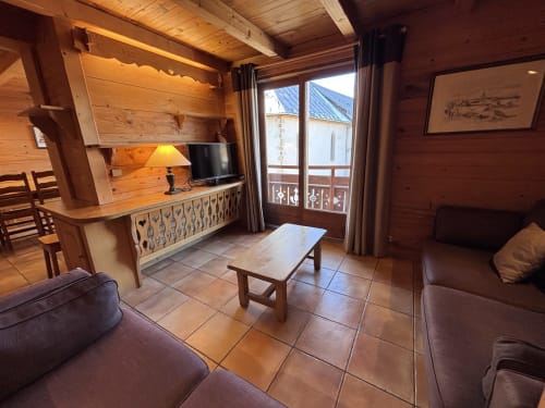 Cozy apartment living room at Chez Marion in Notre Dame de Bellecombe with wooden beams, mountain view balcony, and modern