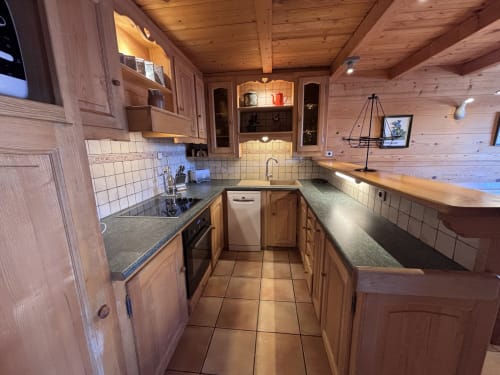 Fully equipped galley kitchen in Chez Marion apartment at Chez Francine, Notre Dame de Bellecombe, with wooden cabinets and