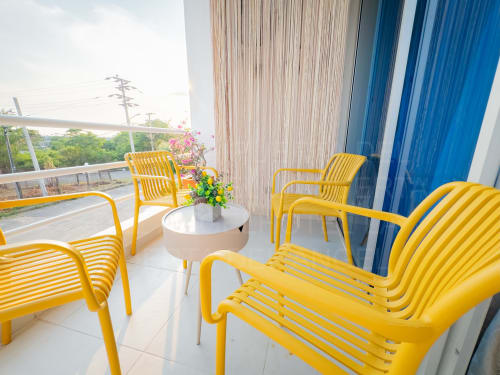 Sillas de descanso amarillo brillante en la terraza soleada del hotel La Puerta del Angel en Ricaurte, Colombia, con vistas a las montañas