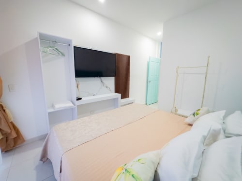 Moderno dormitorio doble en La Puerta del Ángel, Ricaurte con TV, aire acondicionado, armario y puerta menta