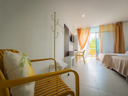 Habitación moderna en La Puerta del Angel con silla amarilla, cama doble, balcón con vista al río, aire acondicionado y luminosa