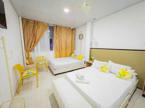 Habitación 211 del hotel La Puerta del Angel en Ricaurte con camas gemelas, detalles en amarillo y mobiliario moderno