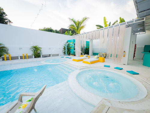 Área moderna de piscina y jacuzzi en el hotel La Puerta del Angel en Ricaurte con asientos lounge y paisajismo tropical