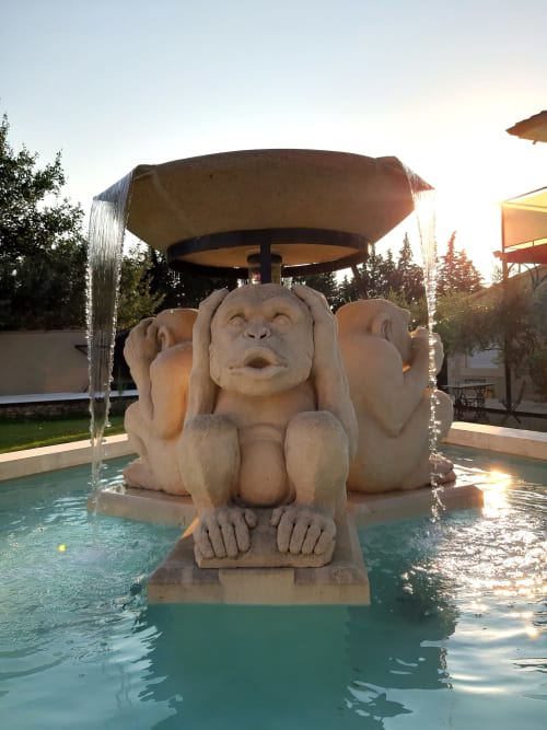 Fontaine sculpture de singe en pierre dans un bassin turquoise au boutique-hôtel Le Mas d'Andiol, Plan d'Orgon
