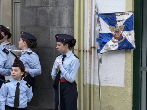 Young cadets in uniforms stand by a blue and white flag at Ribeirinha, Azores location