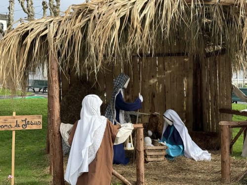 Nativity scene display at Golden Mermaid Villa in Ribeirinha with figures in traditional clothing under thatched roof