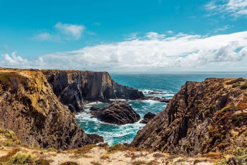 Falésias dramaticamente escarpadas e oceano turquesa em Cerro da Campaniça, Santiago do Cacém Portugal