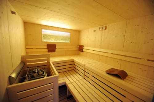 Moderne Sauna im Rustclea Apartments in Selva di Valgardena mit Holzbänken, Ofen und Fenster