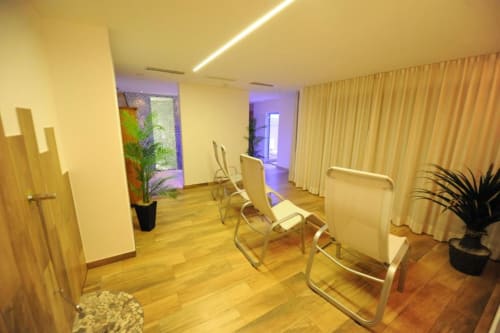 Moderner Hotelflur in den Rustclea Apartments in Selva di Valgardena mit Holzböden, modernen Stühlen und Ambiente
